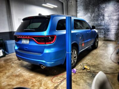 A blue suv parked in a garage with its trunk open.