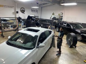 A man standing in front of two cars.