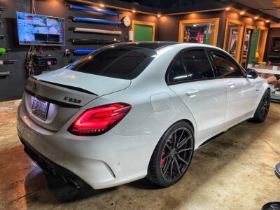 A white car parked in a garage with some lights