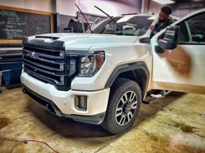 A man is standing next to a white truck.