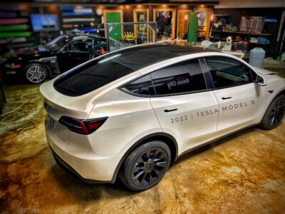 A white tesla model x parked in a showroom.