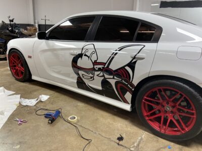 A white car with red and black designs on the side.