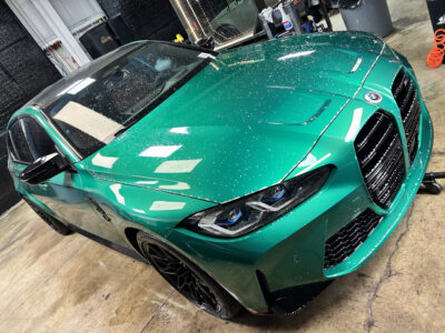 A green car is parked in the garage.