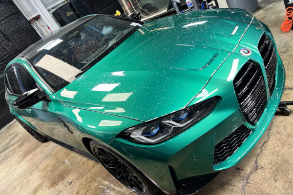 A green car is parked in the garage.