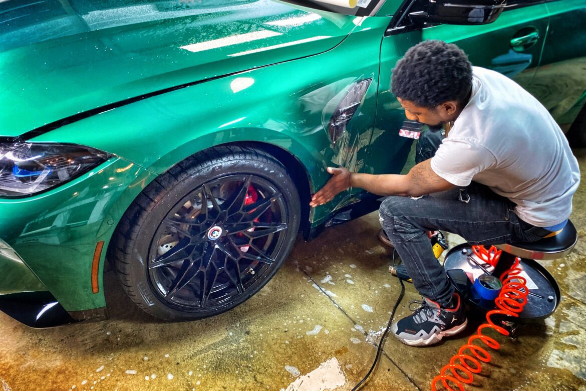 A man is painting the rim of his car.