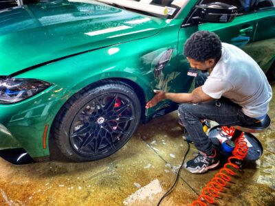 A man is painting the rim of his car.