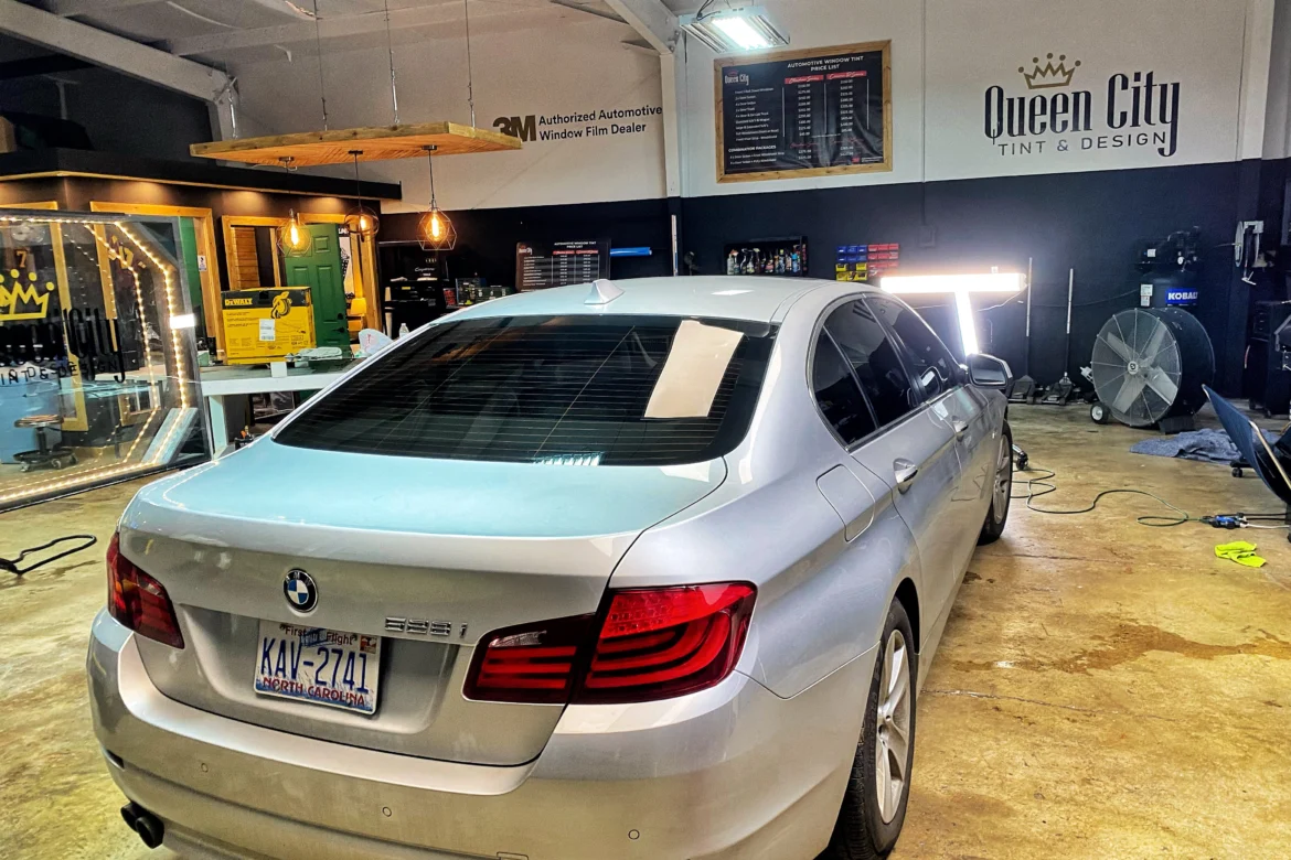 A silver car parked in a garage with other cars.
