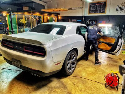 A man is loading the back of a white car.