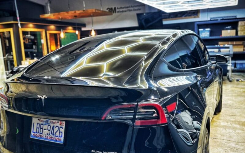Black Tesla Model Y in showroom.