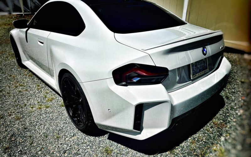 White BMW M2 rear view parked.